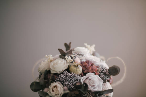 istock Beautiful floral composition with fresh flowers on wooden table in floristic studio. 1324051797