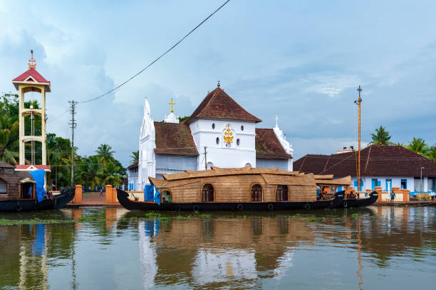 Kerala Backwaters - Kochi in southern India Tourist rice barge (houseboat) moored near a Christian Church on the inland waterways of the Kerala Backwaters, near Kochi in southern India. kochi india stock pictures, royalty-free photos & images