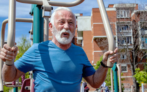 istock Senior man exercises on public gym equipment. 1324054390