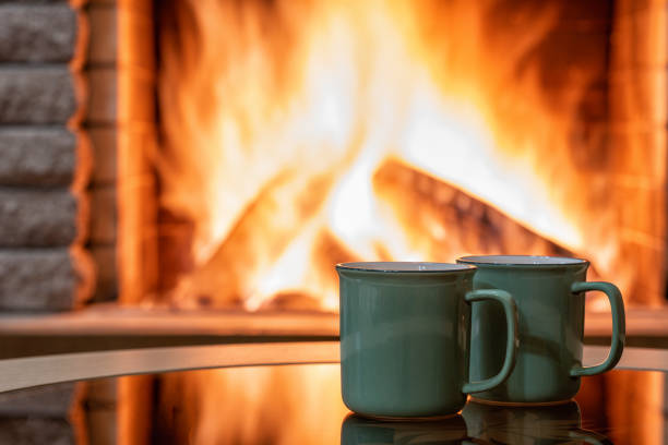 istock Cozy Fireplaceand and green tea mugs , orange fire. 1324054953