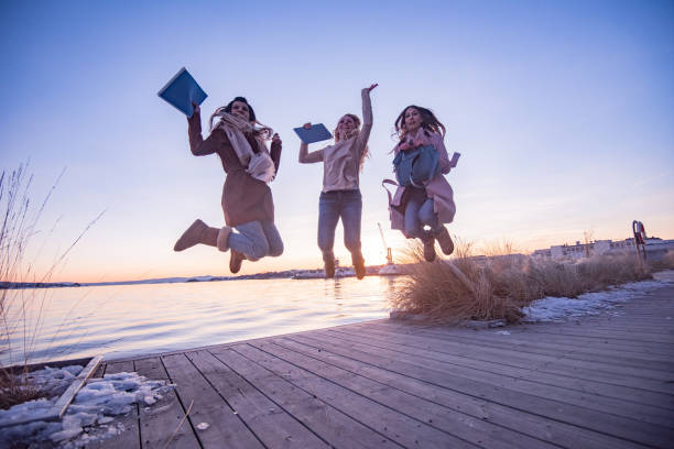 istock Young female students having fun jumping outdoors 1324057086