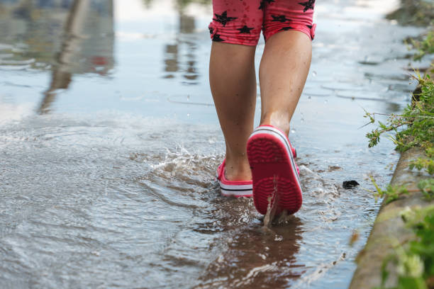istock Children's feet walking in a muddy puddle after the rain 1324057216