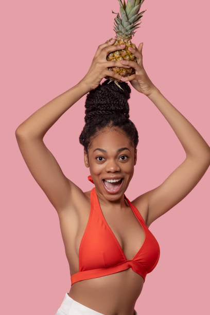 istock Young african american woman with a pineapple having fun 1324059177