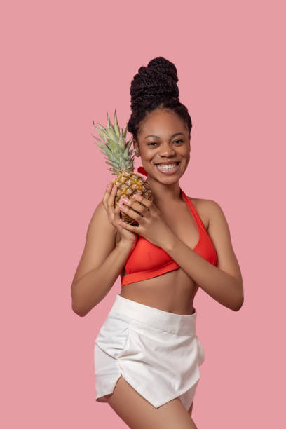 istock Young african american woman with a pineapple having fun 1324059187