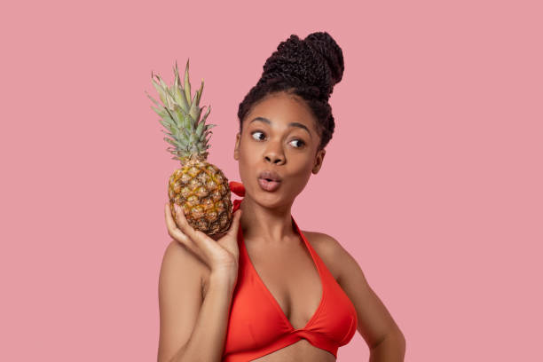 istock Young african american woman with a pineapple having fun 1324059191