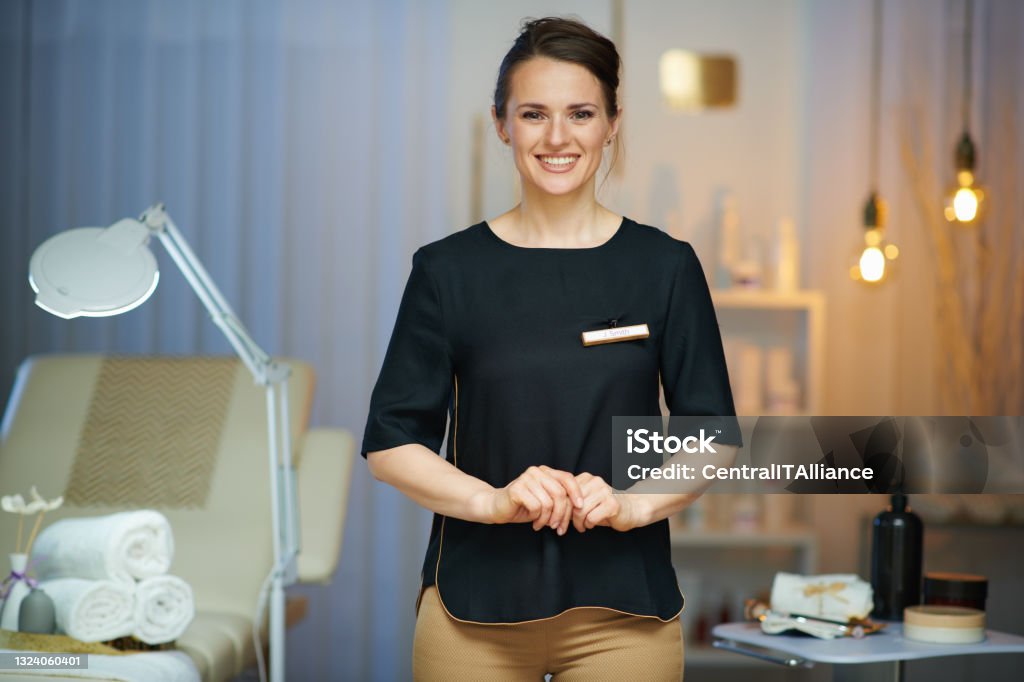smiling 40 years old woman worker in modern beauty salon smiling 40 years old woman worker in modern beauty salon. Beauty Spa Stock Photo
