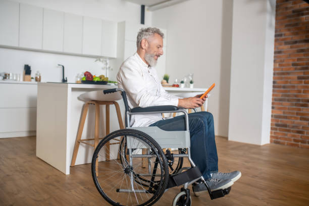 istock Gray-haired handicapped man with a tablet in hands 1324062429