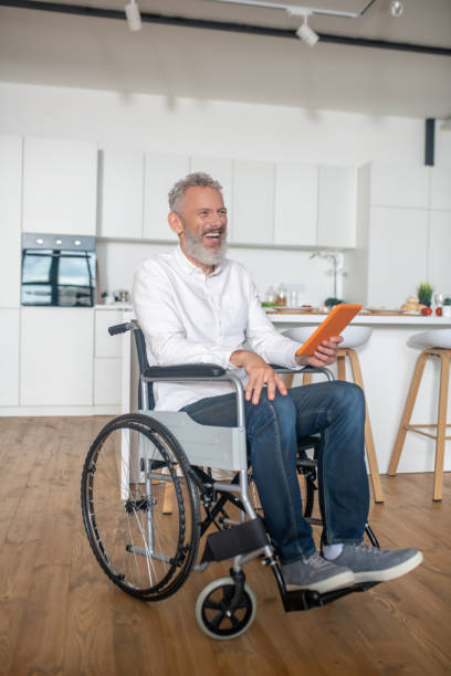istock Gray-haired handicapped man with a tablet in hands 1324062443