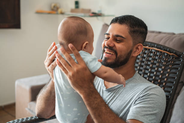istock Father son baby smiles chair 1324063280