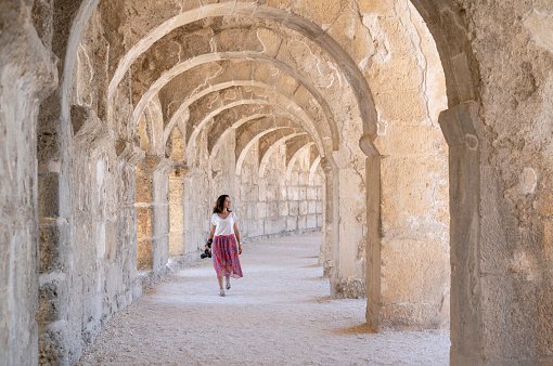 Female tourist taking pictures The Ancient Roman Theatre of Aspendos, Mediterranean Coast, Antalya, Turkey