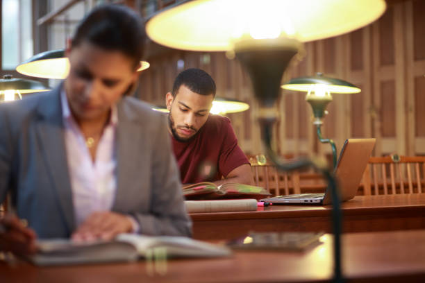 istock Young afro-american man studying in the library 1324069430