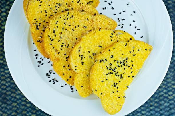 istock Sweet garlic bread biscuits with black sesame on plate - blue background. 1324070690