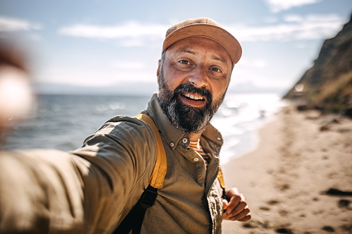Mature man make selfie on the beach
