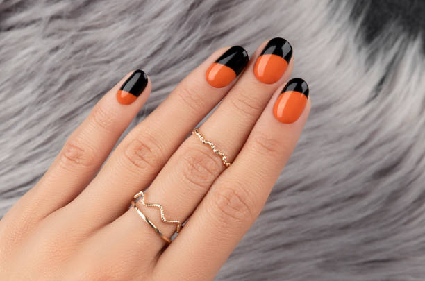 Manicured womans hand over furry background Manicured womans hand over furry background. Trendy autumn halloween orange nail design. fall nail art stock pictures, royalty-free photos & images