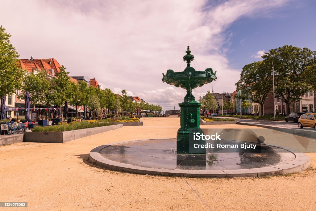 Fountain on the square in the city of Vlissingen in Holland. The background is a blue sky with white clouds and the morning sun shines. Fountain on the square in the city of Vlissingen in Holland. The background is a blue sky with white clouds and the morning sun shines."n Białystok Stock Photo