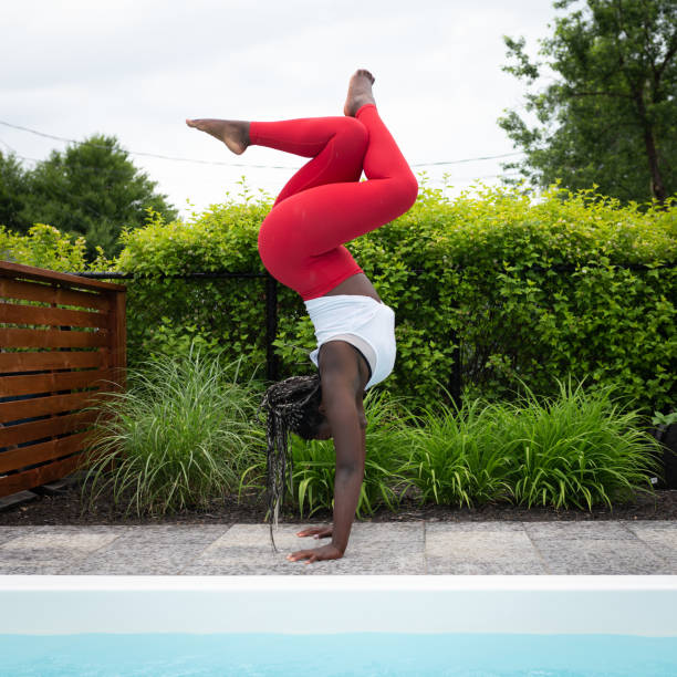 jeunes femmes pratiquant le handstand - équilibre sur les mains photos et images de collection