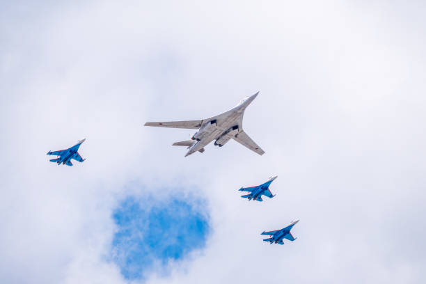 The Tu-160 strategic missile carrier, accompanied by four Su-35S fighter jets, flies over Red Square during the preparation of the May 9 parade. Moscow, Russia - May, 05, 2021: The Tu-160 strategic missile carrier, accompanied by four Su-35S fighter jets, flies over Red Square during the preparation and rehearsal of the May 9 parade. tu160 stock pictures, royalty-free photos & images