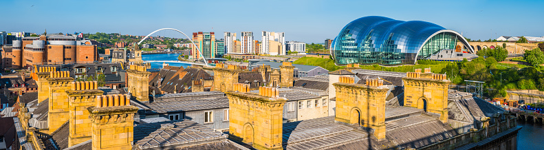 Panoramic view over the rooftops of Newcastle River Tyne quayside past the Gateshead Millennium Bridge to the Baltic Centre and Sage Gateshead, Tyne and Wear, UK.