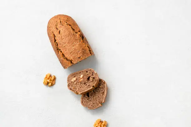 Top view of homemade einkorn bread with walnuts in slices, copy space