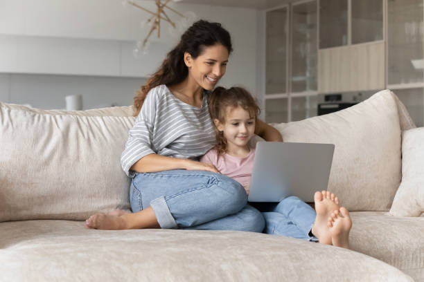 istock Happy Hispanic mom and little daughter use laptop 1324096492