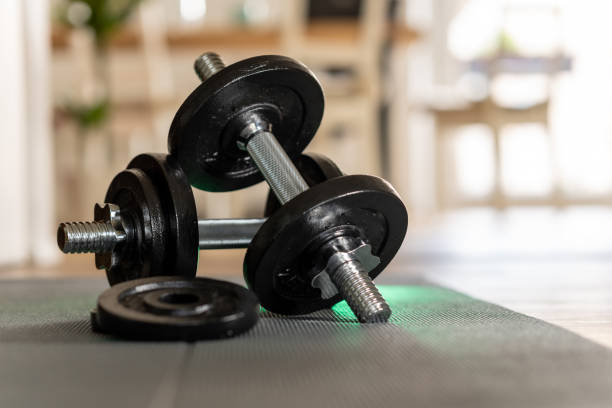 istock Dumbbells lie on a mat, bright background. Sport in the home office during remote work. 1324098526
