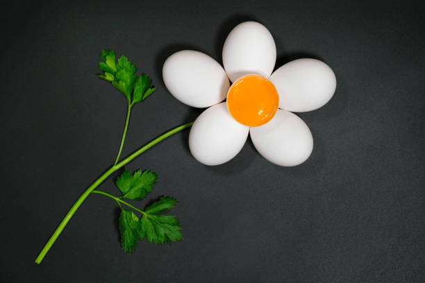 istock Flower made from chicken eggs and parsley on a dark background. Top view 1324099916
