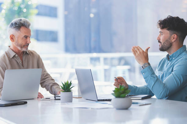 istock Two businessmen working with technology. Both are wearing casual clothing. 1324102277