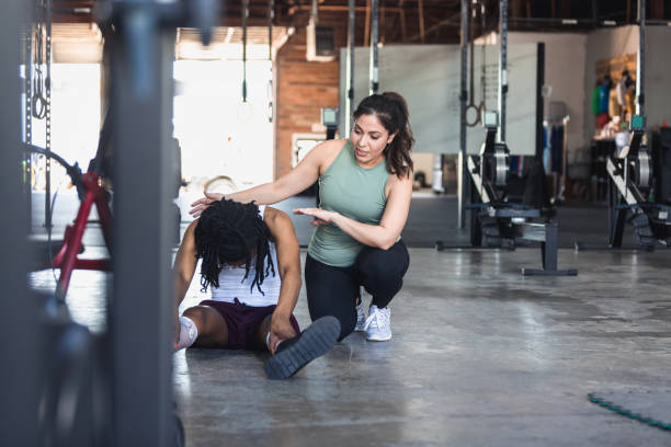 istock Female trainer teaches female client how to do sit up 1324103248