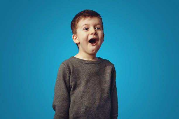 istock Surprised little cute boy screaming omg isolated over blue background 1324104755