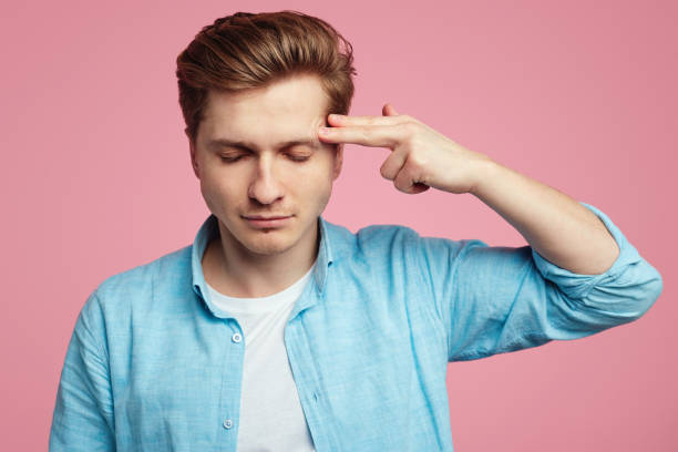 istock Man shoots in temple with finger, demonstrates suicide gesture 1324104762