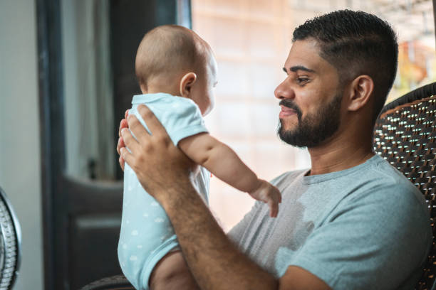 istock Father playing baby son rocking chair 1324105823
