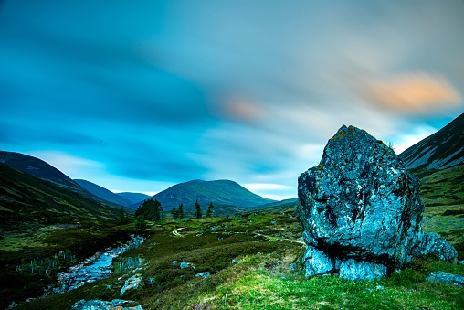 Large Boulder with mountain scene in the background long exposure