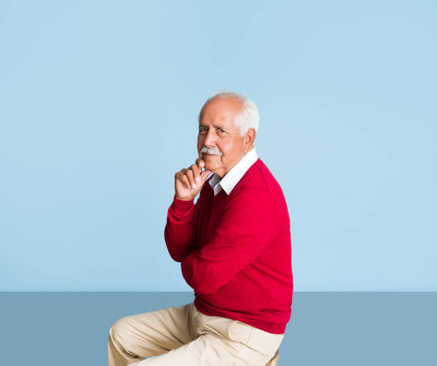 istock Lovely senior man sitting and looking at camera 1324116345
