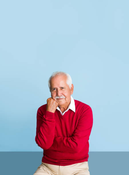 istock Senior man with fist on face and looking at camera 1324116348