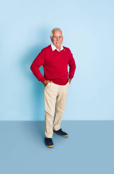 istock Cute senior man standing with hands in pockets 1324116871