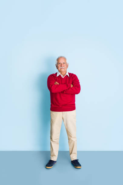 istock Senior man looking up with arms crossed 1324116876
