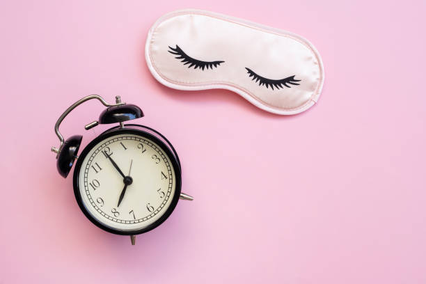 istock Healthy sleep concept with mask, alarm on black 1324117138