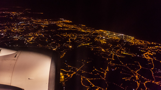 aerial view from airplane window at night on city lights and turbine