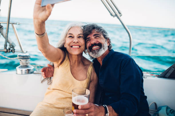 Selfie from the sailing adventure Senior couple taking a selfie while cruising on their yacht. yacht selfie stock pictures, royalty-free photos & images