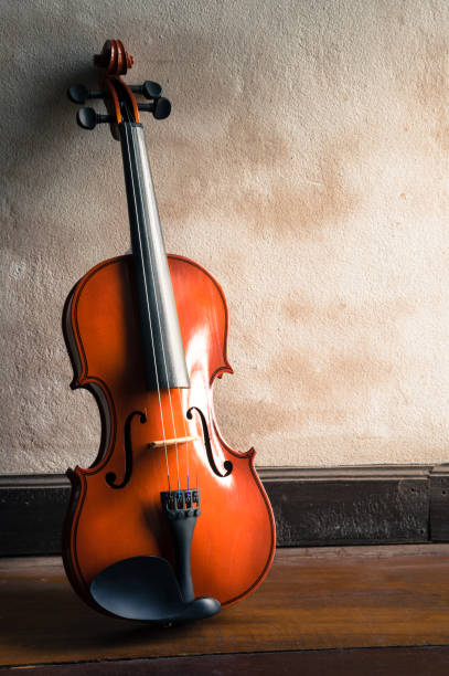 istock Wooden violin with old grunge wall. 1324123288