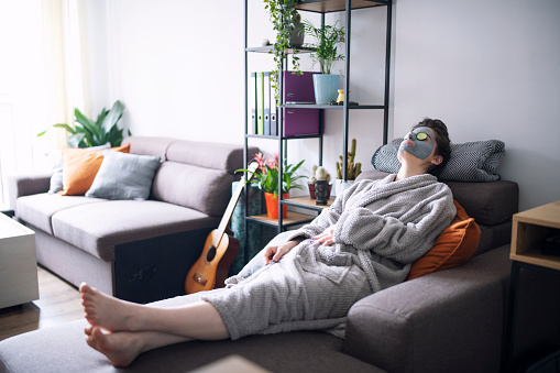 Woman with a facial mask relaxing at home