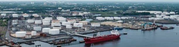 istock Drone elevated view on the industrial cargo ship unloading at the petroleum terminal in New Jersey, on the Arthur Kill tidal strait at the border with New York State. High resolution aerial stitched panorama. 1324124765