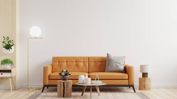 istock Living room interior wall mockup in warm tones with leather sofa on white wall background. 1324130837