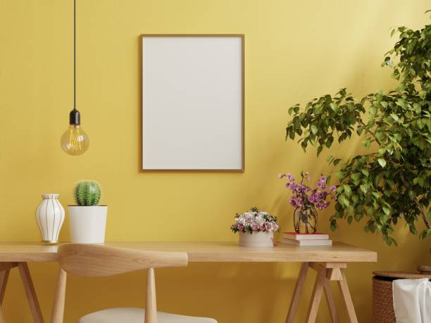 istock Mockup frame on work table in living room interior on empty yellow wall background. 1324131039