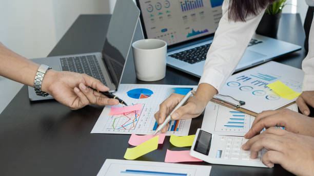 istock Businessmen discuss charts and analyze graphs showing successful teamwork on a desk with laptop and calculator. 1324133572
