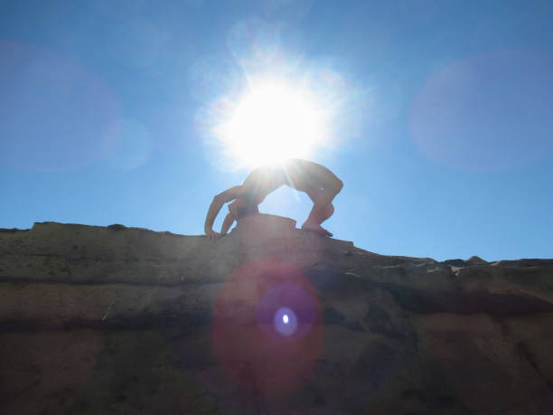 naked man practicing yoga in bridge pose - yoga nudist silhouette naked imagens e fotografias de stock