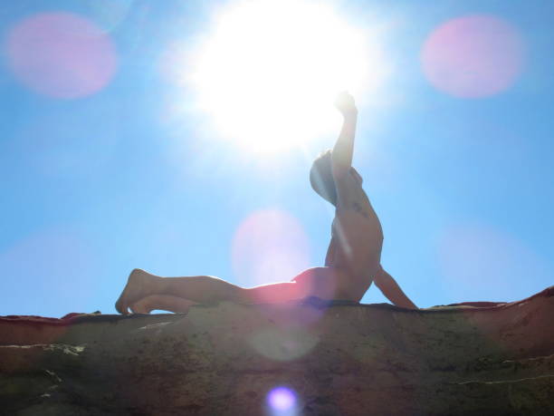 nackter mann punching die luft in der sonne - yoga nudist silhouette naked stock-fotos und bilder