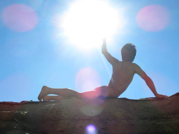 naked man punching the air in the sun - yoga nudist silhouette naked imagens e fotografias de stock