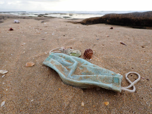 istock Washed-up Surgical Facemask Medical Waste On Beach 1324139384