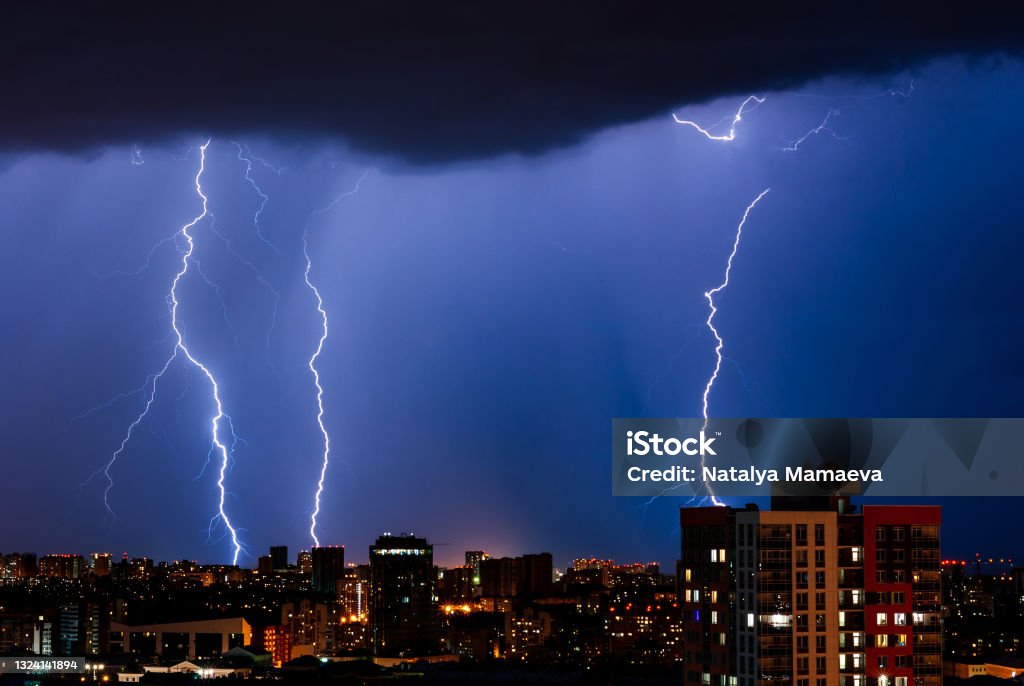 Lightning in night city Thunderstorm with lightning over the night city Lightning Stock Photo